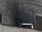 Le conduit de cheminée est plié avec un coude et positionné au milieu d’un mur près d’une fenêtre.